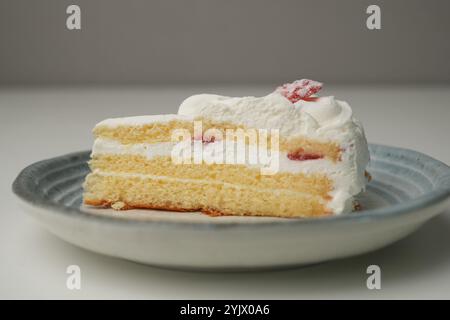 Ein kleiner japanischer Erdbeer-Shortcake auf einem stilvollen japanischen Teller auf einem weißen Tisch. Stockfoto