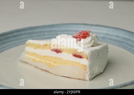 Ein kleiner japanischer Erdbeer-Shortcake auf einem stilvollen japanischen Teller auf einem weißen Tisch. Stockfoto