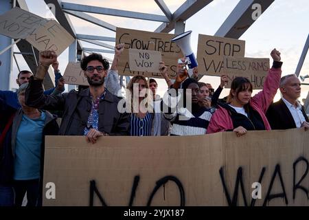 Gruppen von Menschen kamen zusammen, um gegen den Krieg zu protestieren, indem sie Banner und Fäuste hochhoben Stockfoto