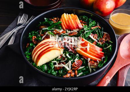 Toskanischer Grünkohl-Salat mit Äpfeln, Pekannüssen und Pepitas: Salat mit weißem Cheddar, kandierten Nüssen, geschnittenen Äpfeln und Vinaigrette-Dressing Stockfoto