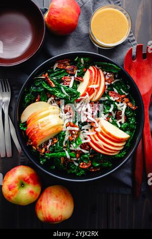 Toskanischer Grünkohl-Salat mit Äpfeln, Pekannüssen und Pepitas: Salat mit weißem Cheddar, kandierten Nüssen, geschnittenen Äpfeln und Vinaigrette-Dressing Stockfoto