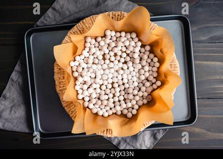 Pecan Shortbread Cookie Pie Crust Teig mit Tortengewichten: Blind gebackene Tortenkruste mit Pergamentpapier ausgelegter und mit Keramikgewichten gefüllter Tortenkruste Stockfoto