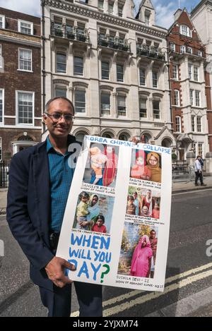 London, Großbritannien. August 2017. Ein Anwalt, der Korba drei Monate nach dem desatösen Schornsteinsturz besuchte, hält ein Poster mit seinen Fotos von einigen Witwen bei der Proteste von Grass Roots Kampagne Foil Vedanta vor der Vedanta AGM. Sie beschuldigen Vedanta des illegalen Bergbaus in Goa, der zunehmenden Belästigung, Folter und falscher Anschuldigungen gegen Stammesaktivisten in Nyamgiri, Odisha, die indische Gesetze benutzt haben, um den Bauxitabbau auf ihrem heiligen Berg zu stoppen, elf Jahre ruinöser und anhaltender Verschmutzung durch Konkola Copper Mines (KCM) in Sambia, wo sie behaupten, dass das Unternehmen betrügerische av habe Stockfoto