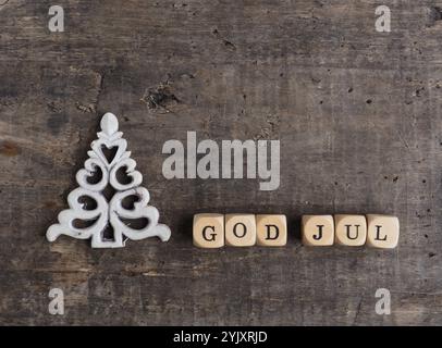 Weihnachtsbaumform mit Holzblöcken und den Worten God Jul, skandinavische frohe Weihnachten auf hölzernem Hintergrund Stockfoto