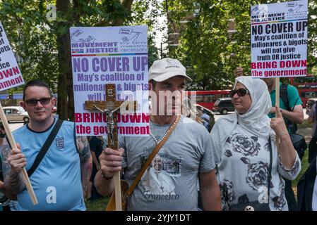 London, Großbritannien. Juni 2017. Ein Mann hält ein Kruzifix und ein Plakat mit der Aufschrift, das Feuer im Grenfell-Turm nicht zu vertuschen, zu Beginn des "Day of Rage"-marsches von Movement for Justice, der vielleicht leider benannt wurde, und ermöglicht es den rechten Medien, sich einem Phantasieextravaganz zu ergehen, der sich einen gewalttätigen Aufstand über Movement for Justice vorstellt, der eine lange Geschichte friedlicher, aber aktiver Proteste hat, die hauptsächlich gegen die ungerechte und illegale Behandlung von Flüchtlingen und Asylsuchenden in Großbritannien gerichtet ist. Aber heute herrscht eine ganze Menge völlig berechtigter Wut über das systembedingte Versäumnis, sich um die Bereitstellung zu kümmern Stockfoto