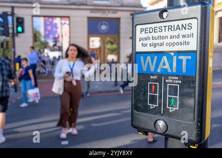 Taste und grünes Signal aktivieren, um Fußgängern auf der Spur Platz zu geben, London.UK. Stockfoto