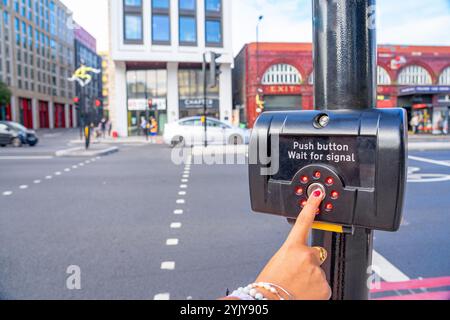 Taste und grünes Signal aktivieren, um Fußgängern auf der Spur Platz zu geben, London.UK. Stockfoto