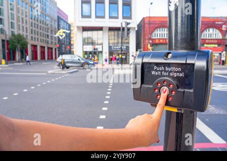 Taste und grünes Signal aktivieren, um Fußgängern auf der Spur Platz zu geben, London.UK. Stockfoto