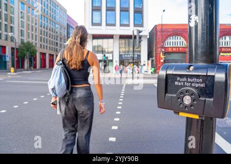 Taste und grünes Signal aktivieren, um Fußgängern auf der Spur Platz zu geben, London.UK. Stockfoto