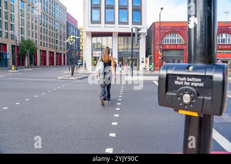 Taste und grünes Signal aktivieren, um Fußgängern auf der Spur Platz zu geben, London.UK. Stockfoto