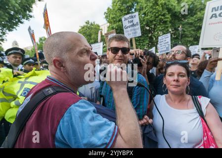 London, Großbritannien. Juni 2017. Michael Bradley spricht vor der Downing Street, wo Demonstranten, die sich weigerten, auf den Pflaster gegenüber zu ziehen, eine laute Kundgebung vor den Toren veranstalteten, bei der Sprecher der North Kensington Community Aktivisten, Bewohner anderer Turmblöcke untergebracht und Rassismus verteidigt wurden. Sie riefen zum Rücktritt von Theresa May und ihrem Helfer Gavin Barwell auf, der als Wohnungsminister die nach der letzten Londoner Turmblockbrandkatastrophe empfohlenen Änderungen nicht umgesetzt hatte. Nach einer Kundgebung zogen sie dort auf, um zu weiteren Protesten bei der BBC und anderswo zu marschieren. Stockfoto