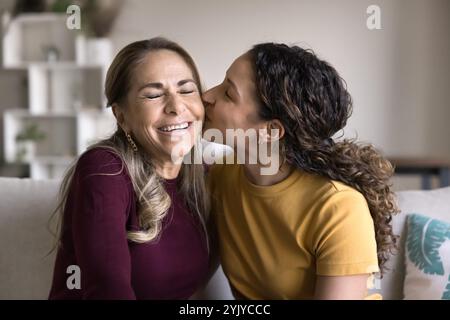 Liebe brasilianische Tochter Frau, die glückliche ältere Mutter umarmt und küsst Stockfoto