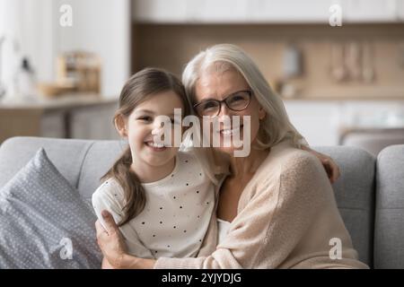 Liebevolle Großmutter kuschelt ihre kleine 6s entzückende Enkelin Stockfoto