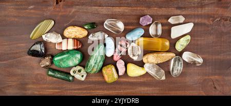 Bunte Mineralsteine auf hölzernem Hintergrund. Schmuckbanner aus Edelsteinen. Stockfoto