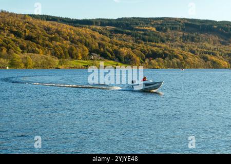 Ein Motorboot auf Coniston Water mit seinem Bug in der Luft gleitet an einem hellen Herbsttag A während der Coniston Power Boat Records Woche über den See. Stockfoto