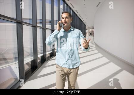 Ernsthaft beschäftigter erfolgreicher Geschäftsmann, der auf dem Handy spricht Stockfoto