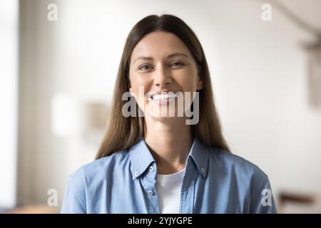 Hübsche Frau in lässigem Denim-Hemd, die in die Kamera schaut Stockfoto