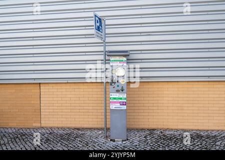 Parkuhr auf einer Kopfsteinpflasterstraße neben einem Parkschild Stockfoto