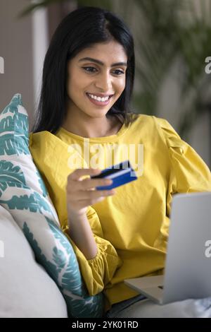 Fröhliche attraktive junge Indianerin mit Kreditkarte Stockfoto