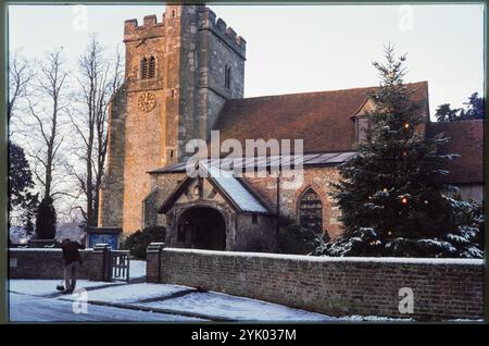 St. John the Baptist's Church, Little Missenden, Chiltern, Buckinghamshire, 1976. St. John the Baptist's Church von der Village Road aus gesehen, mit einem Mann, der Schnee vom Tor entfernt. Stockfoto