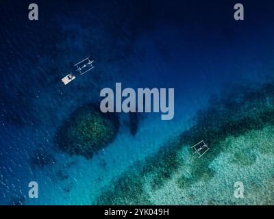 Blick auf das Meer aus der Vogelperspektive über das blaue Meer mit Korallenriff und Booten auf Bali Stockfoto
