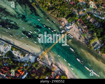 Aus der Vogelperspektive auf eine Brücke, die zwei tropische Inseln über einen schmalen Meereskanal verbindet. Nusa Lembongan und Nusa Ceningan in Indonesien. Stockfoto