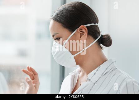 Geschäft, Frau und Fenster mit Gesichtsmaske im Büro für Quarantäne, Gesundheit Compliance und einsam. Denken, weibliche Person und Virus-psa für die Zukunft Stockfoto