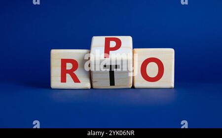 RPO vs. RTO-Symbol. Holzwürfel mit den Worten RTO bis RPO. Wunderschöner tiefblauer Hintergrund. Geschäftskonzept. Kopierbereich Stockfoto