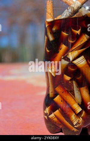 Zigarettenkippen in einer Plastikflasche Stockfoto