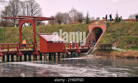 Ein Winterblick auf den Burggraben der Bourtange mit einer historischen Zugbrücke, umgeben von schneebedeckten Landschaften und Weihnachtsmarkt-Besuchern, die schlendern Stockfoto