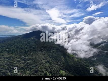 Drohnenblick auf den Vulkan mombacho mit Wolken, die den Gipfel in Nicaragua am sonnigen Tag verbergen Stockfoto