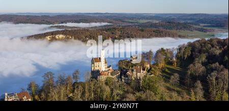 Sonnenschein in den Bergen, Nebel im Echaz-Tal. Schloss Lichtenstein auf der Schwäbischen Alb. Das Märchenschloss Württemberg ist ein cas aus dem 19. Jahrhundert Stockfoto