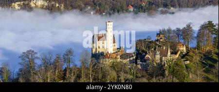 Sonnenschein in den Bergen, Nebel im Echaz-Tal. Schloss Lichtenstein auf der Schwäbischen Alb. Das Märchenschloss Württemberg ist ein cas aus dem 19. Jahrhundert Stockfoto