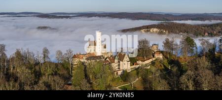 Sonnenschein in den Bergen, Nebel im Echaz-Tal. Schloss Lichtenstein auf der Schwäbischen Alb. Das Märchenschloss Württemberg ist ein cas aus dem 19. Jahrhundert Stockfoto