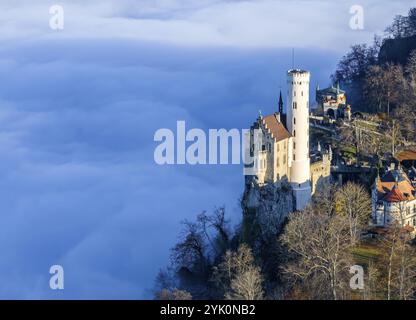 Sonnenschein in den Bergen, Nebel im Echaz-Tal. Schloss Lichtenstein auf der Schwäbischen Alb. Das Märchenschloss Württemberg ist ein cas aus dem 19. Jahrhundert Stockfoto