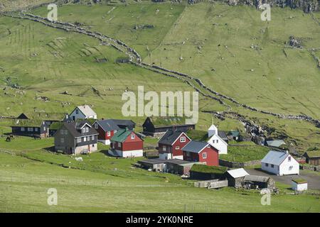 Alte Mauern, die an den Weg der Schafe am Schaftrieb Grenzen, Wiesen, Häuser in traditioneller färöischer Bauweise aus Holz auf einem Steinfuß, einige mit einem Stockfoto