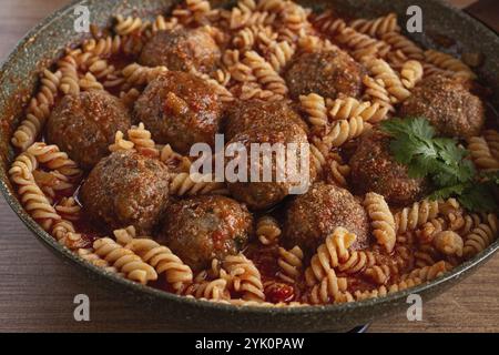 Hackfleischbällchen, in Tomatensauce, mit Fusilli-Nudeln, in einer gusseisernen Pfanne, selbstgemacht, keine Leute Stockfoto