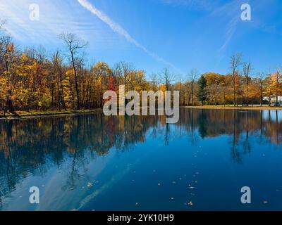 An einem späten Herbstmorgen im Sommer leuchten die Herbstfarben über einen Teich in einem Stadtpark im Nordosten von Ohio. Stockfoto
