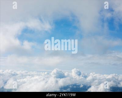 Der Himmel bietet leuchtend blaue Bereiche, die zwischen weichen, dicken Wolken sichtbar sind und eine ruhige Atmosphäre schaffen. Stockfoto