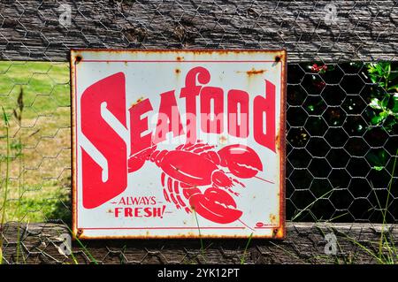 Ein altes emailliertes Metallblech-Schild, das frische Meeresfrüchte auf einem Zaun in Cornwall anpreist. Stockfoto