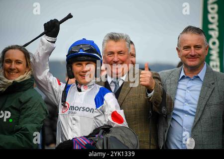 Cheltenham, Großbritannien. November 2024. Freddie Gingell (Jockey) feiert mit Verbindungen wie Trainer Paul Nicholls (Daumen nach oben), nachdem er 2,20 den Paddy Power Gold Cup Handicap Turmjase auf der Cheltenham Racecourse gewonnen hatte. Foto von Paul Blake/Alamy Images 16/11/2024 Stockfoto