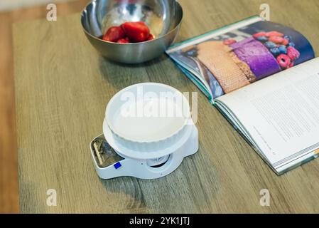 Zucker auf digitaler Küchenwaage mit Kekszutaten zum Backen auf Holztisch. Hochwertige Fotos Stockfoto