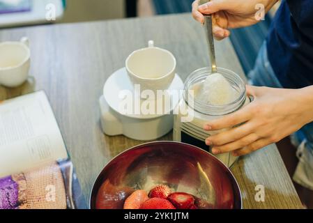 Zucker auf digitaler Küchenwaage mit Kekszutaten zum Backen auf Holztisch. Hochwertige Fotos Stockfoto