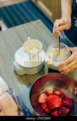 Zucker auf digitaler Küchenwaage mit Kekszutaten zum Backen auf Holztisch. Hochwertige Fotos Stockfoto