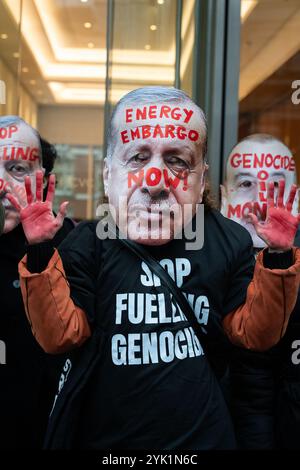 London, Großbritannien. November 2024. Eine Aktivistin trägt eine Maske, die den Präsidenten der Türkei Recep Tayyip Erdoğan vor dem Londoner Büro der Staatlichen Ölgesellschaft der Aserbaidschanischen Republik (SOCAR) darstellt, während eine Koalition aus über sechzig Klimakampagnen-Gruppen und palästinensischen Unterstützern durch Zentral-London marschiert und die Regierung fordert, unsere Abhängigkeit von fossilen Brennstoffen zu beenden, für Klimafinanzierung aufzukommen und Israels Krieg gegen Gaza nicht mehr zu unterstützen. Aserbaidschan, das derzeit Gastgeber der Klimaverhandlungen auf der COP29 ist, liefert schätzungsweise 30 % des israelischen Öls über die Türkei. Quelle: Ron Fassbender/Alamy Live News Stockfoto