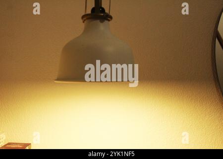 Eine hellweiße Lampe in der Dämmerung. Beleuchtungsprobleme in einem Zimmer, einer Wohnung, einem Haus, einem Zimmer. Stockfoto