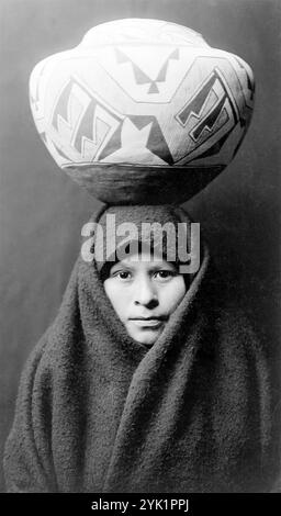 Ein Kopf-und-Schultern-Porträt eines Zuni-Mädchens aus dem Jahr 1903 mit einem Töpfergefäß auf dem Kopf. Foto von Edward Curtis. Edward Sheriff Curtis war ein us-amerikanischer Ethnoggraph und Fotograf, der viele Jahre seines Lebens damit verbrachte, die riesige 20-bändige Serie The North American Indian zu erforschen und zu illustrieren. Stockfoto