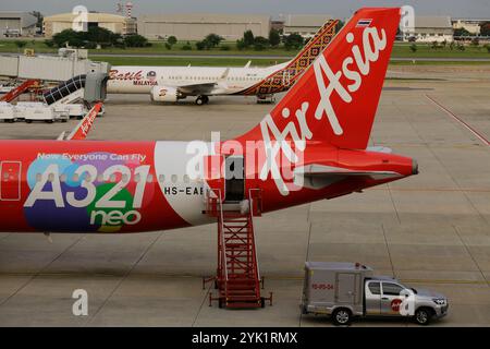 Bangkok, Thailand - 29. Juni 2023: Flugzeuge der Billigfluggesellschaft AirAsia werden vor dem Abflug am Flughafen Don Mueang (DMK) am Gate geparkt. Stockfoto