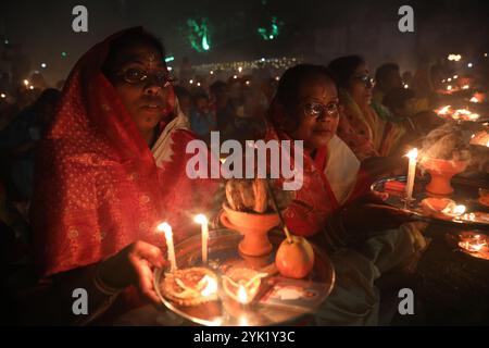 Kalkutta, Westbengalen, Indien. November 2024. Hindugeweihte sitzen zusammen vor Öllampen und beten zu Shri Shri Loknath Brahmachari, einem hinduheiligen und Philosophen, während sie das Rakher Upobash Festival beobachten, in einem Tempel in Chakla Dham und Tempel etwa 69 km nördlich von Kolkata, Indien, am 16. November 2024.Hindufrauen beobachten ein eintägiges Fasten und Gebete während des ''Kartik Brata' oder ''Rakher Upobash' oder ', um ihre Kinder zu heilig zu sein und Wohlgefallen. und die Reinigung ihrer eigenen Körper und Seelen. (Bild: © Rupak de Chowdhuri/ZUMA Press Wire) EDITORI Stockfoto