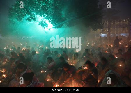 Kalkutta, Westbengalen, Indien. November 2024. Hindugeweihte sitzen zusammen vor Öllampen und beten zu Shri Shri Loknath Brahmachari, einem hinduheiligen und Philosophen, während sie das Rakher Upobash Festival beobachten, in einem Tempel in Chakla Dham und Tempel etwa 69 km nördlich von Kolkata, Indien, am 16. November 2024.Hindufrauen beobachten ein eintägiges Fasten und Gebete während des ''Kartik Brata' oder ''Rakher Upobash' oder ', um ihre Kinder zu heilig zu sein und Wohlgefallen. und die Reinigung ihrer eigenen Körper und Seelen. (Bild: © Rupak de Chowdhuri/ZUMA Press Wire) EDITORI Stockfoto